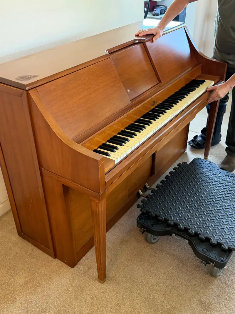 Upright piano secured on a heavy-duty piano dolly during a move in San Luis Obispo